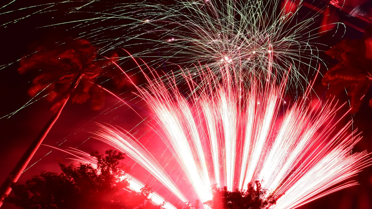 Feu d’artifice rouge du réveillon à La Réunion, palmiers en silhouette